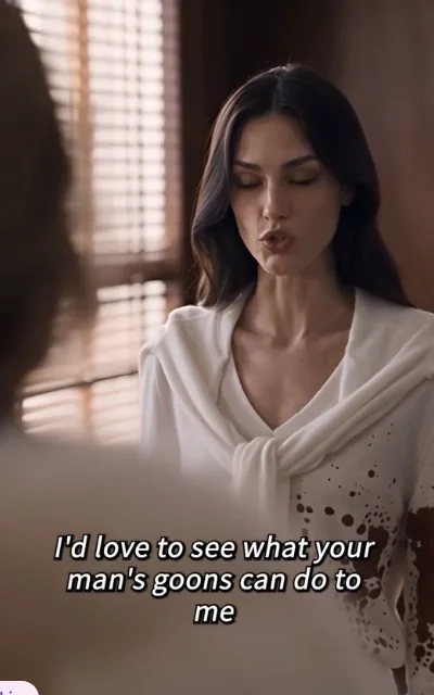 Valencia in blood-stained white before the blinds, chin up, subtitle: I'd love to see what your man's goons can do to me